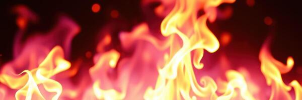 Fire flames dancing in vibrant colors creating a dramatic atmosphere in a dark setting photo