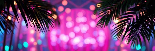 Colorful lights shine through palm leaves at a vibrant outdoor event in the evening photo