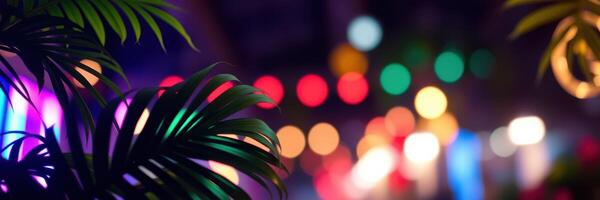 Vibrant lights illuminate a lively street adorned with tropical plants at night photo