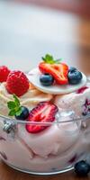 Delicious bowl of mixed berry and ice cream dessert with fresh fruits and mint leaves on a wooden table photo