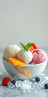 Colorful ice cream scoops with fresh fruit in a bowl on a marble countertop photo