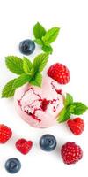 Fresh raspberry and blueberry ice cream topped with mint leaves on a white background photo