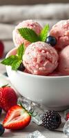 Delicious pink ice cream served in a bowl with fresh berries and mint leaves on a wooden table photo