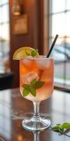 Refreshing drink served in a stylish glass garnished with mint and lemon in a cozy setting at sunset photo