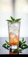 Refreshing mint beverage served in a clear glass with ice and a hint of orange photo