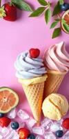 Colorful ice cream cones topped with strawberries and accompanied by citrus slices on a pink background photo