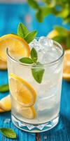 Refreshing lemonade with mint and ice on a colorful blue wooden table during summertime photo