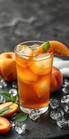 Refreshing peach iced tea served in a glass with fresh peach slices and mint leaves on a dark surface photo