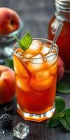 Refreshing iced tea with peach and mint served in a glass alongside fresh fruits on a rustic wooden table photo