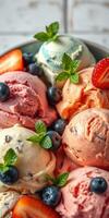 Delicious assortment of colorful ice cream scoops garnished with fresh fruit and mint leaves photo