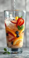 Refreshing fruit-infused drink prepared with fresh strawberries, blueberries, and citrus slices in a clear glass photo
