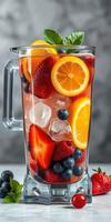 Refreshing fruit beverage in a blender filled with strawberries, blueberries, and citrus slices prepared for summer enjoyment photo