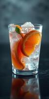 Refreshing citrus drink with ice and orange slices on a dark background photo