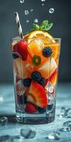 Refreshing fruit drink with berries and citrus served in a tall glass with ice and a striped straw photo