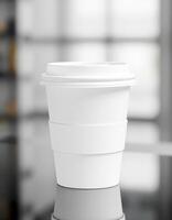 Empty coffee cup sitting on table with blurred background in a modern cafe setting photo