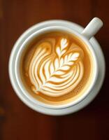 Elegant latte art showcases intricate design in a warm coffee cup on a wooden table photo