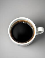 Freshly brewed black coffee in a white mug on a simple gray surface during morning hours photo