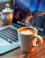 Cozy workspace with a latte and laptop in a sunlit room during morning hours photo