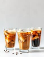 Refreshing iced coffee drinks served in clear glasses with ice cubes and coffee beans on a white background photo
