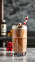 refrescante caramelo chocolate sacudir servido con azotado crema y a rayas Paja en un elegante vaso foto