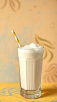 Creamy milkshake served in a tall glass with whipped cream and a colorful straw on a patterned background photo