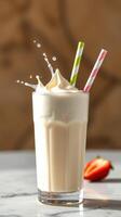 Creamy milkshake with whipped cream and colorful straws served in glass on a marble table photo