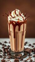 Indulgent chocolate milkshake topped with whipped cream and chocolate drizzle served with chocolate pieces photo