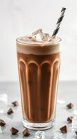 Refreshing iced chocolate beverage with ice cubes and a striped straw in a glass photo