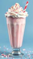Delightful pink milkshake topped with whipped cream and sprinkles on a pastel blue background photo