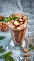 Delicious iced chocolate drink topped with mint and nuts on a marble surface photo