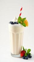 Creamy vanilla milkshake topped with fresh berries and mint leaves ready to enjoy on a sunny day photo