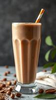 Creamy nutty beverage served in a tall glass with a decorative straw and surrounded by coffee beans photo