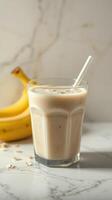 Delicious banana smoothie with oats served in a glass on a marble countertop photo