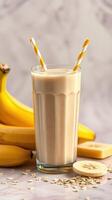 Creamy banana smoothie with oats and fresh bananas served in a tall glass photo