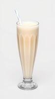Creamy milkshake served in a tall glass with a straw on a neutral background photo