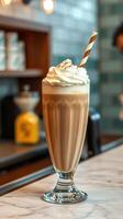 Creamy coffee shake topped with whipped cream and a striped straw ready to be enjoyed in a cozy cafe photo