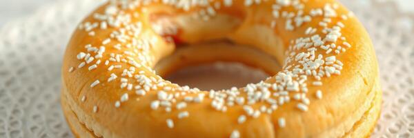 Delicious sweet pastry topped with white sprinkles on a decorative lace cloth photo