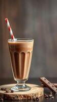 Unique chocolate milkshake served in a glass with a straw surrounded by chocolate bars and coffee beans photo