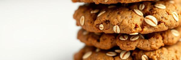 Homemade oatmeal cookies stacked high on a clean countertop in bright kitchen light photo