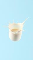 Milk splash created from a container against a light blue background captures the dynamic nature of liquid movement photo