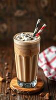 Creamy iced coffee topped with whipped cream and chocolate sprinkles served in a tall glass with straws photo