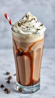 Creamy chocolate milkshake topped with whipped cream and chocolate shavings in a glass photo