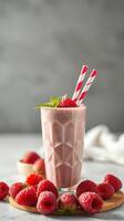 Refreshing raspberry smoothie served in a tall glass with garnishes and fresh raspberries on a wooden board photo