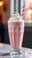 Enjoying a refreshing strawberry milkshake topped with whipped cream and colorful sprinkles in a cozy cafe photo