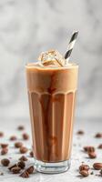 Iced coffee drink with ice cubes and a straw placed on a marble background photo