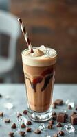 Creamy iced coffee drink with chocolate syrup and straw presented indoors during a cozy setting photo