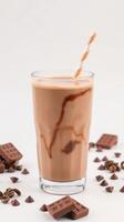 Creamy chocolate milkshake served in a glass with chocolate pieces and coffee beans scattered photo