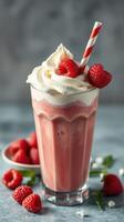 Delicious raspberry milkshake topped with whipped cream and fresh berries in a glass on a textured background photo