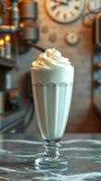 Creamy milkshake topped with whipped cream served in a vintage glass at a cozy cafe setting photo