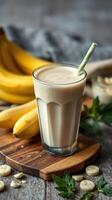 Creamy banana smoothie served in a glass with fresh bananas and a straw on a wooden surface in a cozy kitchen photo